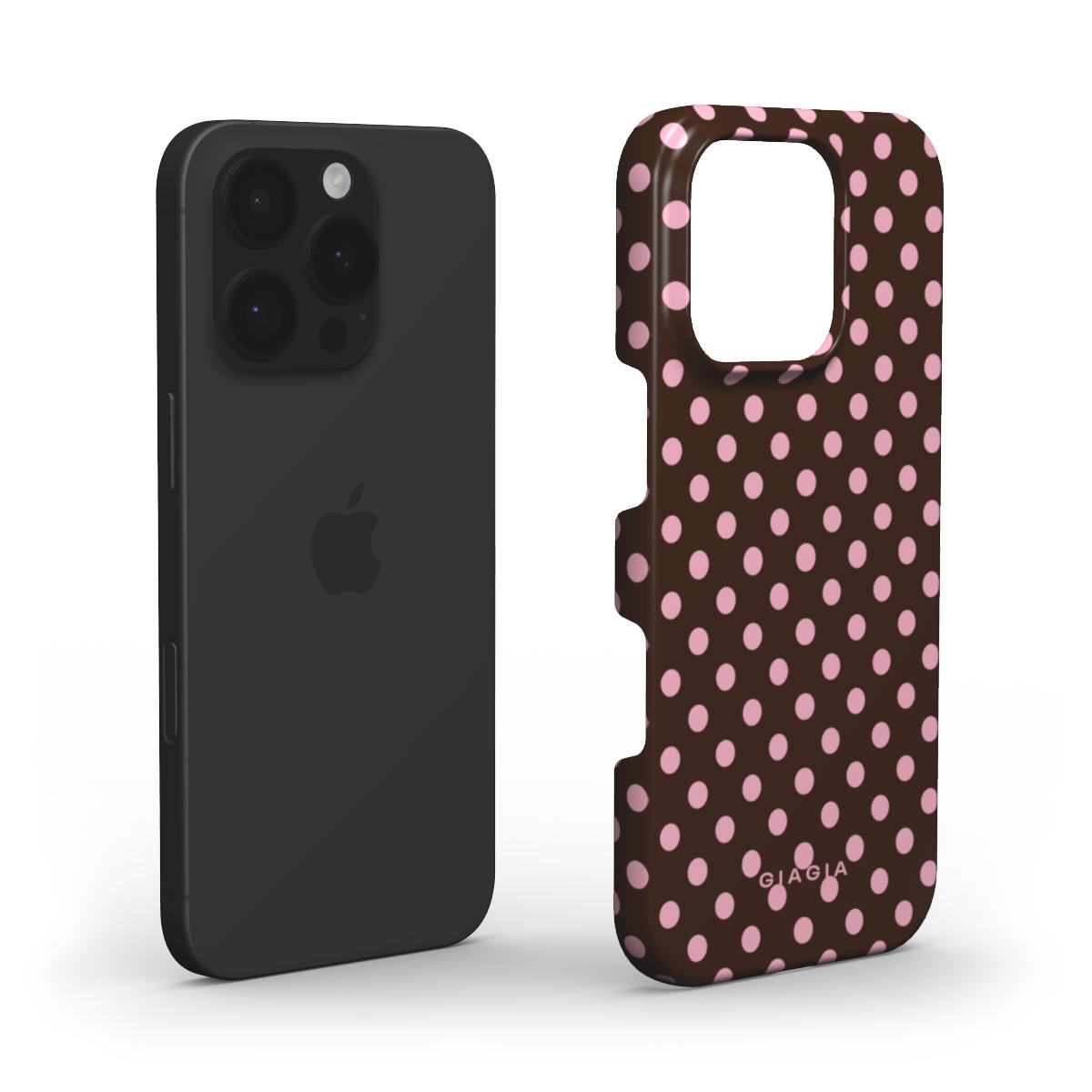 Black phone case next to a brown phone case with pink polka dots on a white background